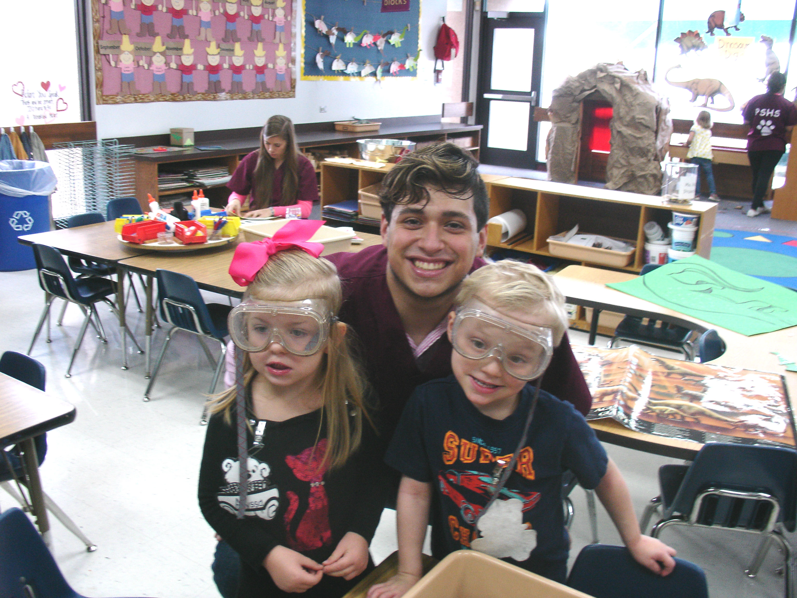 Student Teacher with young girl and boy at science station 